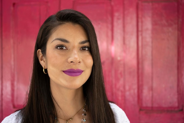 Retrato colorido da mulher mexicana sorrindo em um fundo rosa ao pôr do sol