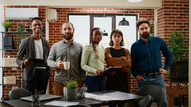 Retrato de compañeros de trabajo que planean una presentación comercial en el cargo, un equipo diverso de personas que trabajan junto con gráficos de datos para planificar la investigación y el informe de la empresa. Grupo profesional de colegas.