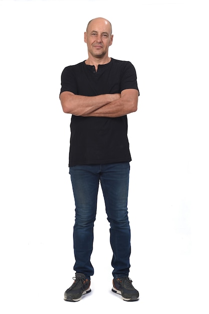 Foto retrato completo de un hombre calvo en blanco, con los brazos cruzados.