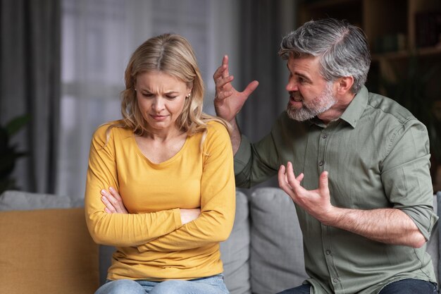 Foto retrato de comportamiento agresivo del marido abusivo gritando a la esposa en casa