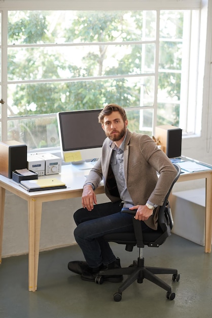 Retrato de computadora y hombre de negocios serio y escritor con confianza trabajando y escritorio cara de proyecto y persona con ambición profesional y empleado en agencia de medios plazo o periodista