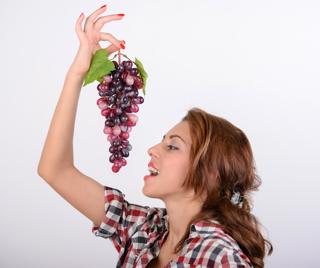 Retrato del concepto de la dieta de la mujer joven con la uva roja