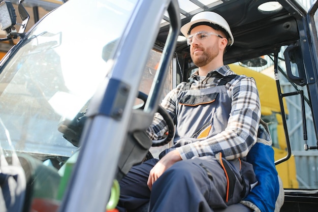 Retrato de un conductor profesional de carretillas elevadoras en el almacén de una fábrica