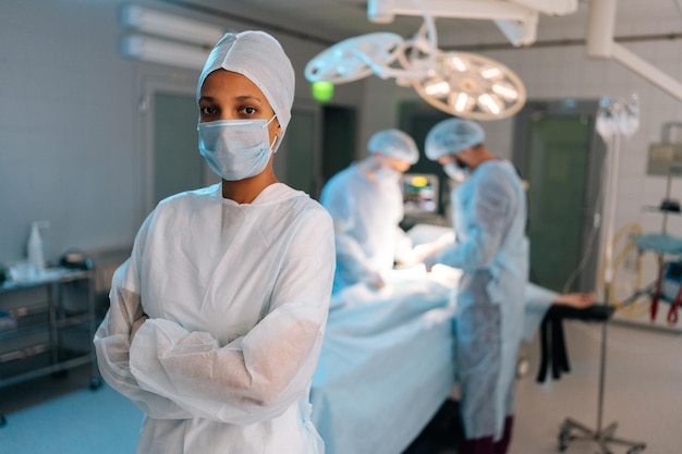 Retrato de una confiada doctora afroamericana de pie posando con los brazos cruzados mirando