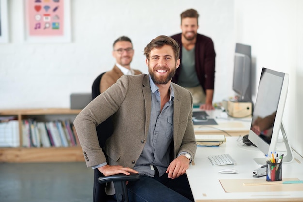 Retrato confiado y creativo de un apuesto hombre de negocios que trabaja en su oficina