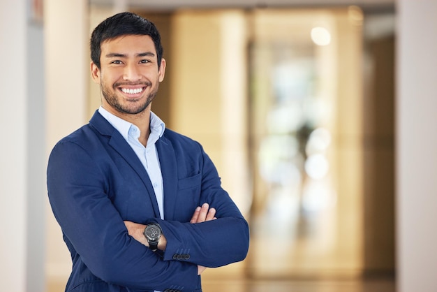 Retrato confiante e um empresário com braços cruzados para trabalho em empresa corporativa e carreira profissional Terno feliz e um jovem funcionário asiático com um sorriso orgulho e felicidade no escritório