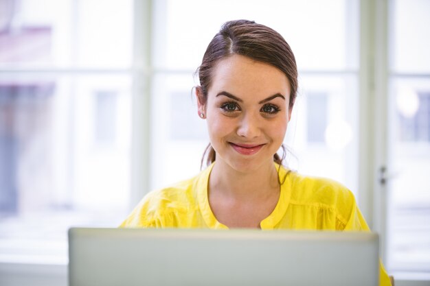 Retrato de confianza empresaria con laptop en la oficina