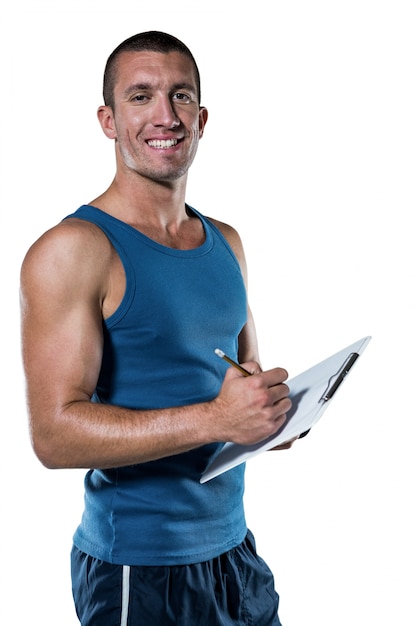 Foto retrato de confianza entrenador deportivo escribiendo en portapapeles