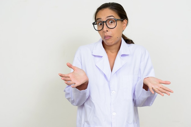 Retrato de confundido médico mujer multiétnica encogiéndose de hombros