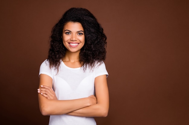 Foto retrato de contenido encantadora chica afroamericana cruzar las manos buena mirada sentir éxito emoción usar ropa de estilo casual.