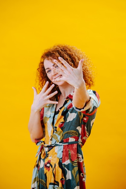 Retrato creativo de una mujer joven sosteniendo sus manos con los dedos separados
