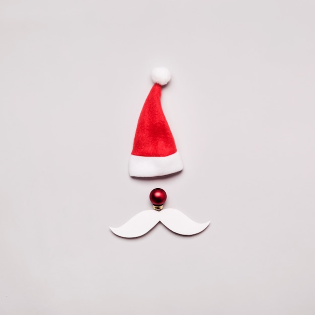 Retrato criativo de Papai Noel de chapéu, bola e bigode de papel cortado. Plano de Natal ano novo lay.