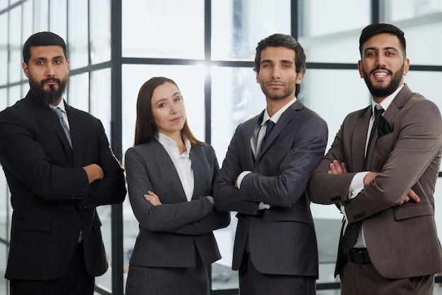 Retrato de cuatro trabajadores de oficina con los brazos sobre el pecho