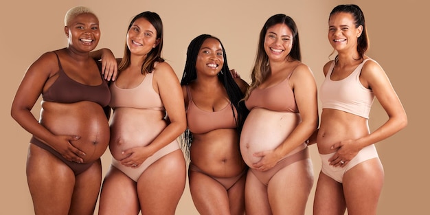 Retrato del cuerpo del embarazo y vinculación de mujeres en el fondo del estudio en el empoderamiento de la diversidad, el apoyo al bebé y la comunidad.