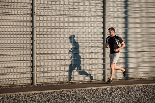 Retrato de cuerpo entero de atlético hombre corriendo