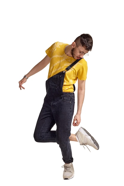 Foto retrato de cuerpo entero de un chico divertido bailando en estudio aislado sobre fondo blanco.