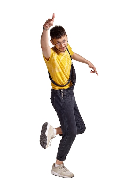 Retrato de cuerpo entero de un chico divertido bailando en estudio aislado sobre fondo blanco.
