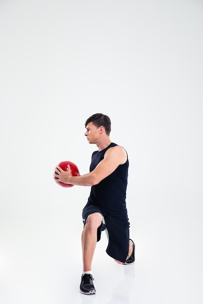 Retrato de cuerpo entero del entrenamiento atlético del hombre con balón de fitness aislado