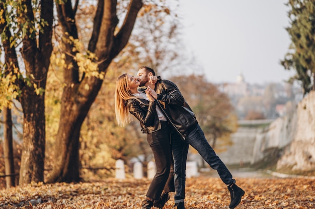 Retrato de cuerpo entero de una feliz pareja amorosa caminando al aire libre en el parque otoño.