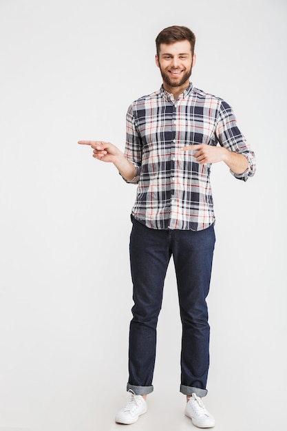 Retrato de cuerpo entero de un hombre alegre apuntando