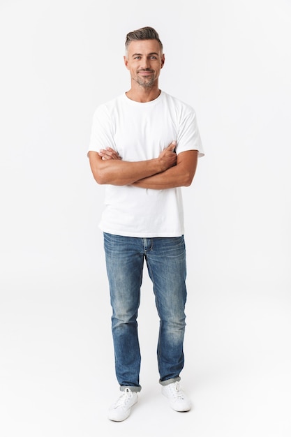 Retrato de cuerpo entero de un hombre guapo de 30 años con camiseta casual y jeans sonriendo aislado en blanco