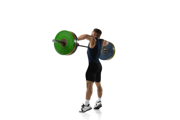 Retrato de cuerpo entero de un hombre en ropa deportiva haciendo ejercicio con un peso aislado sobre fondo blanco.