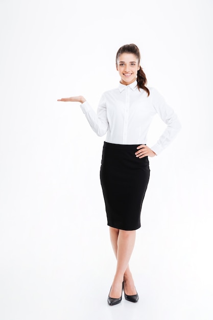 Retrato de cuerpo entero de una joven empresaria hermosa con espacio de copia aislado en la pared blanca