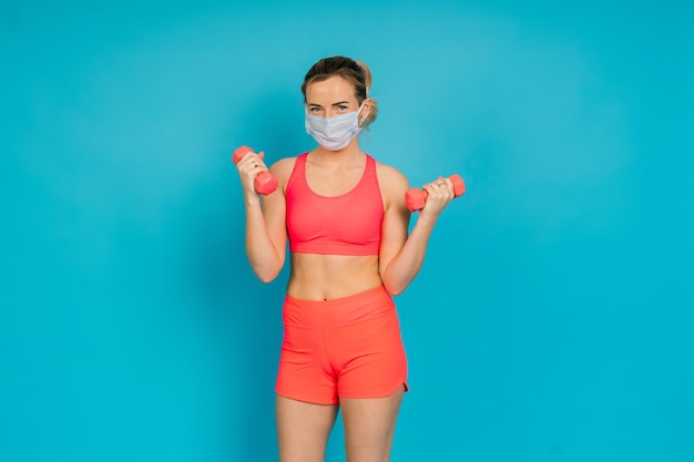 Retrato de cuerpo entero de una joven sonriente en ropa deportiva aislada sobre el fondo del estudio