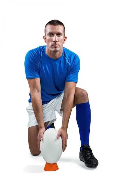 Foto retrato de cuerpo entero del jugador de rugby colocando la pelota