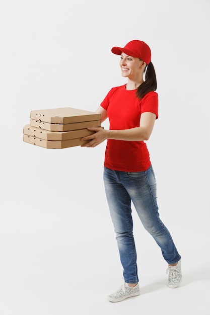 Retrato de cuerpo entero de mujer feliz en gorra roja, camiseta dando cajas de pizza de orden de comida aisladas sobre fondo blanco. Mensajero mujer sosteniendo pizza italiana en caja plana de cartón. Concepto de servicio de entrega.