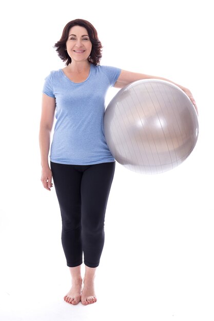 Retrato de cuerpo entero de una mujer madura con balón de fitness aislado sobre fondo blanco.