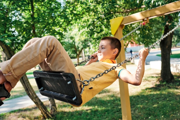 Retrato de cuerpo entero de un niño sosteniendo modelos de planetas mientras disfruta de una lección de astronomía al aire libre en la luz del sol