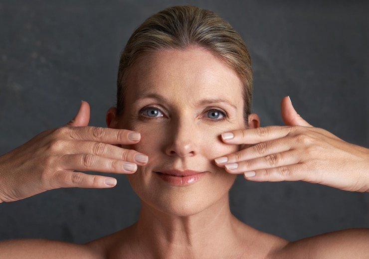 Foto retrato de cuidado de la piel y mujer madura con cara conmovedora y en el fondo del estudio preparación para cosméticos o dermatología en la cabeza de la persona facial y bienestar de la modelo femenina de mediana edad en la parte trasera