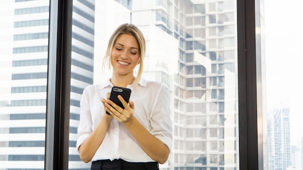 Retrato da bela empresária segurando o telefone no escritório