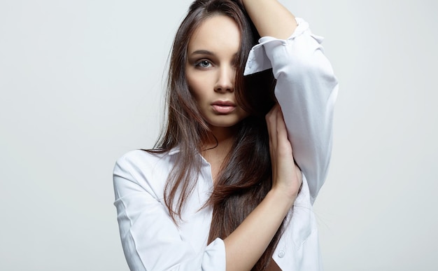 Retrato da beleza da moda de uma mulher bonita no estúdio branco