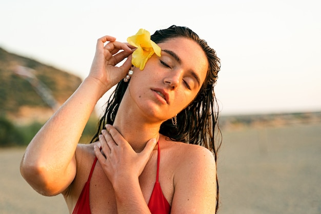 Foto retrato da beleza de jovem com flor amarela após procedimento de spa.