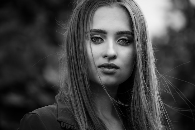 Retrato da beleza de uma jovem menina morena bonita com cabelo preto voador reto longo. Cabelo magnífico. Preto e branco