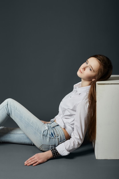 Retrato da beleza de uma linda jovem em um fundo escuro. Cosméticos para adolescentes, tratamento de acne