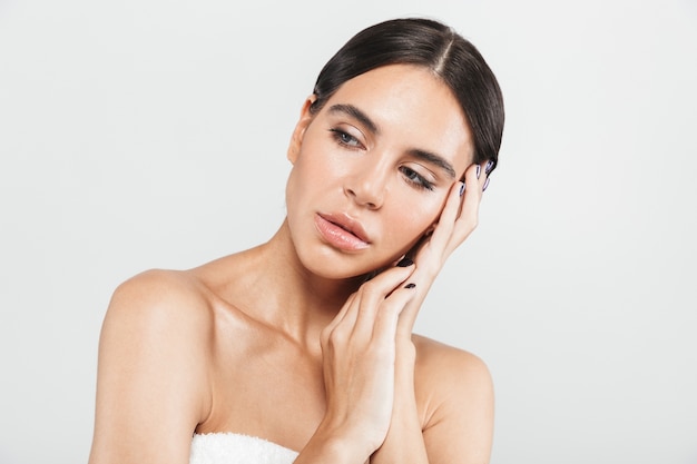 Retrato da beleza de uma mulher atraente e saudável em pé isolado sobre uma parede branca, posando