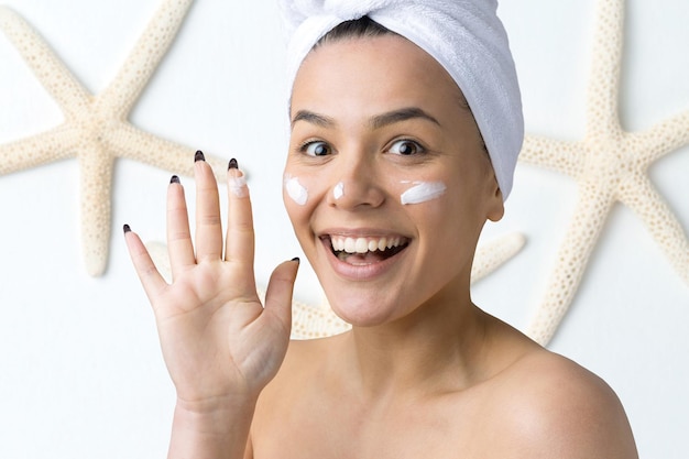 Foto retrato da beleza de uma mulher em uma toalha branca na cabeça com uma esponja para um corpo em vista de um coração rosa