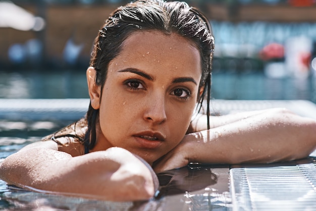 Foto retrato da beleza pura de uma mulher jovem e atraente em trajes de banho, olhando para a câmera em pé