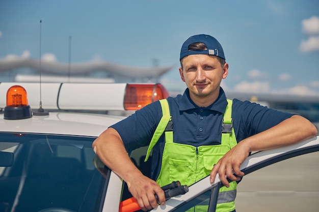 Retrato da cintura para cima de um funcionário do aeroporto com varinhas de comando na mão, posando para a câmera