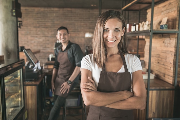 Retrato da dona de um café mestiço sorrindo com orgulho em sua loja