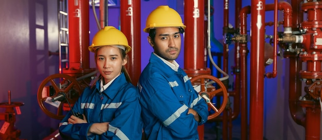 Retrato da equipe de engenheiros mecânicos homem e mulher inspecionam água de qualidade e sistemas de incêndio no edifício Sala de bomba de água e tanque de água de encanamento