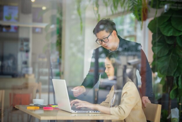 Retrato da equipe de negócios usando o laptop e aplainar o trabalho no café. Reunião de negócios e conceito de brainstorm.