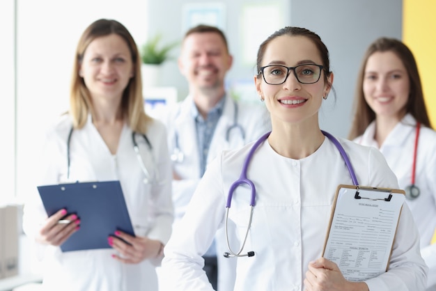 Retrato da equipe médica em pé com a prancheta no hospital