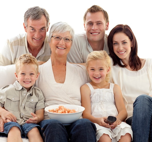 Retrato da família assistindo televisão e comendo batatas fritas