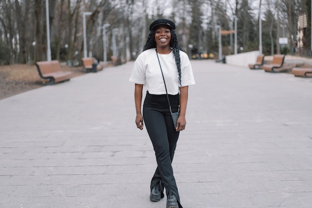 Retrato da foto de alegre garota de pele negra em um parque da cidade.