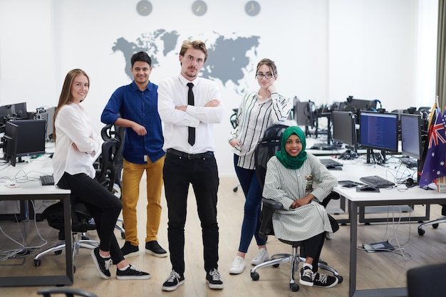 retrato da jovem equipe de negócios multiétnica animada de desenvolvedores de software em pé e olhando para a câmera no escritório de inicialização moderno
