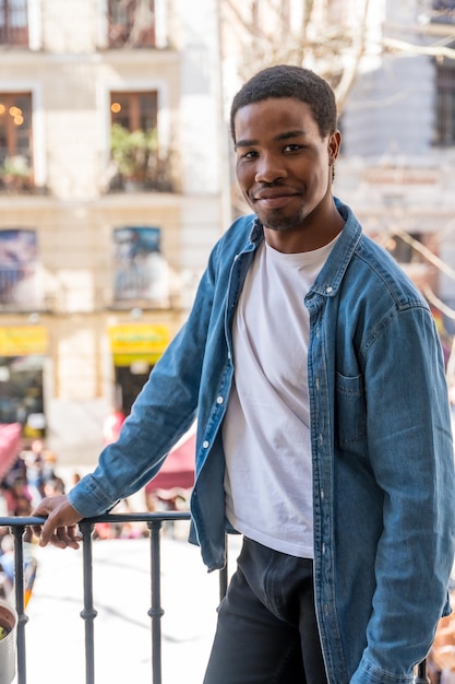 Foto retrato da jovem etnia negra na varanda de casa na cidade